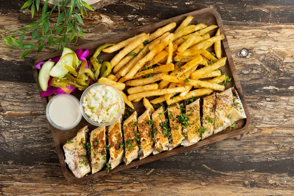 Sliced grilled chicken with seasoned fries and sides